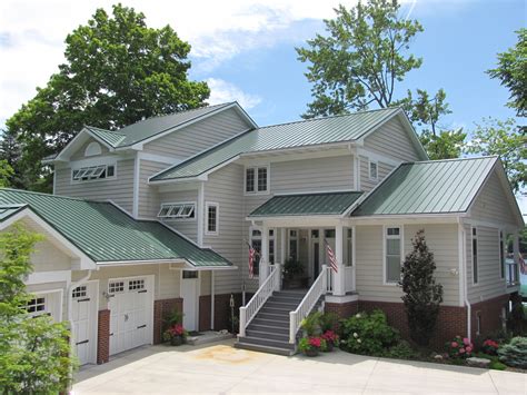 green brick house with white metal roof|house with green roof.